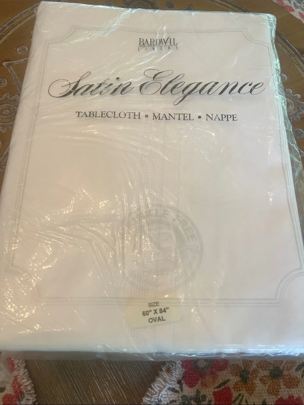 Satin Elegance White Oval Tablecloth by Bardwil Linens. Off white simple cloth.